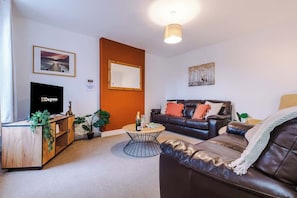 The spacious living space benefits from 2 sofas, a 40-inch smart TV and plenty of space to sit down and relax.