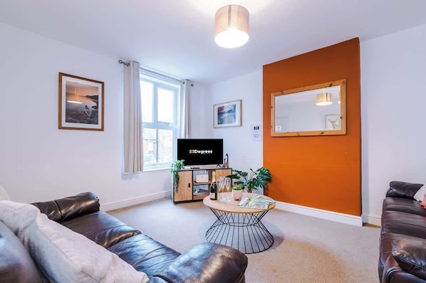 The spacious living space benefits from 2 sofas, a 40-inch smart TV and plenty of space to sit down and relax.