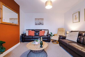 The spacious living space benefits from 2 sofas, a 40-inch smart TV and plenty of space to sit down and relax.