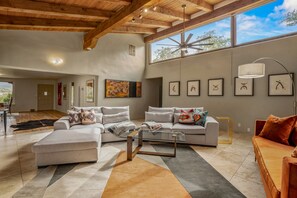 Artfilled living room with view towards dining room.