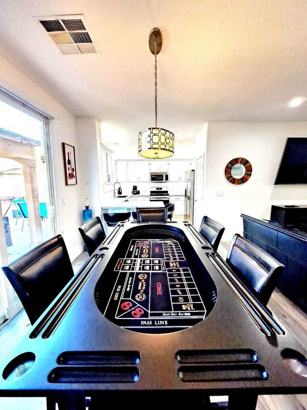 Dual purpose dining table serves as  game table with Poker and Craps.