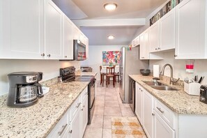 The kitchen features a spacious cabinet, stove, microwave, coffee maker, and toaster