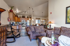 Living Room with plush sofa & loveseat, gas fireplace, 50" TV, and private deck access