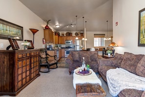 Living Room with plush sofa & loveseat, gas fireplace, 50" TV, and private deck access