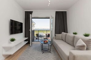 The living area features a sleek coffee table and a flat-screen television.