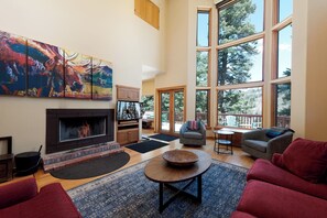 Main Living Space with mountain views, wood burning fireplace, TV and deck access