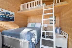 Experience our cozy getaway with a queen-sized bed and a small loft featuring a twin mattress, making it a perfect retreat for both adults and kids alike.