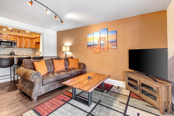 Resort Plaza 5024 living room with comfortable suede couch and flat screen TV.