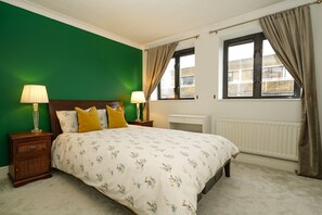 King-size master bed with luxury Tempur mattress & a forest green feature wall.