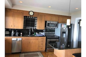 Full Vacation Kitchen, with dishwasher! Has breakfast bar with two chairs.