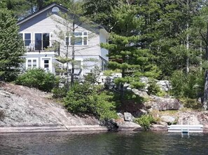 Cottage is nestled in trees close to the shoreline of this Lakefront property