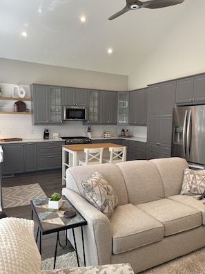 Living Room looking into the spacious and stocked kitchen!