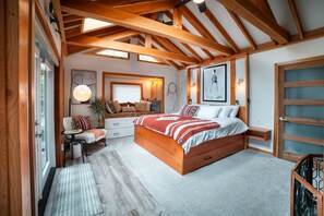 Master bed room features a custom king bed, skylights and large wood beams