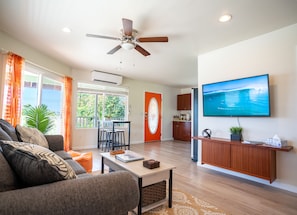 Living room area with open space dining. AC is located above the window