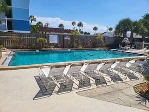 Heated pool with BBQ grills, tables, and chairs