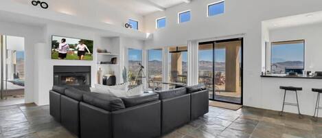 Living room with large sofa, Smart TV, and back deck access