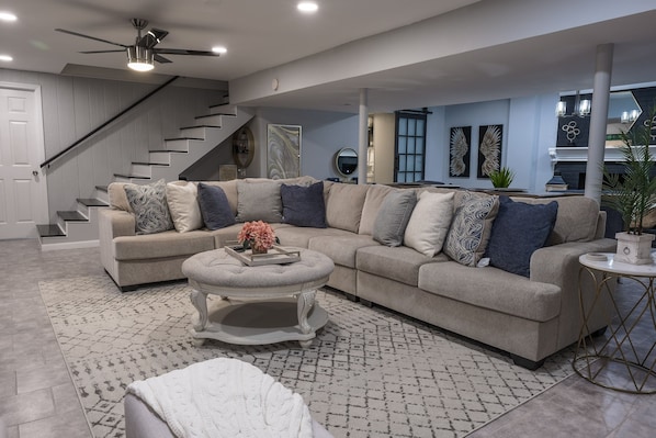 Large living room with 65”TV, comfortable sectional sofa. Plenty of seating.