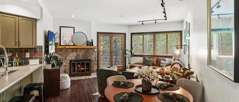 The cozy scene that greets you as you enter highlights the home’s open layout that spans the living, dining and kitchen areas. Here you will find a dining table for four, roomy leather sectional, stone fireplace and a flat-screen TV.