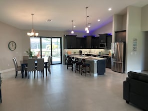 Kitchen and dining area, access to pool. Patio doors open wide. 