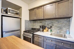 Fully stocked kitchen has extra butcher block table to added counter space.