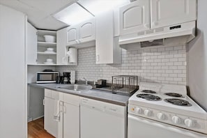 Full kitchen with an electric stove, oven, fridge, freezer, pantry area, dishes, microwave, dishes and all cookware.