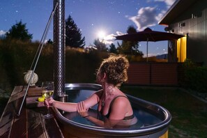 Wood-fired hot tub with spring water heated by sustainably-harvested wood