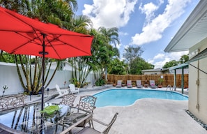 Shaded outdoor dining area overlooking pool.