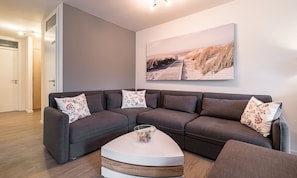 Wohnzimmer mit großer Sofalandschaft und Ausgang zur Terrasse