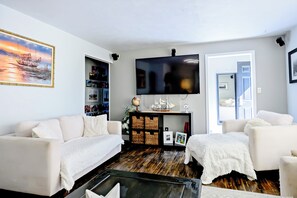 Cozy living area with large smart TV and comfortable seating.