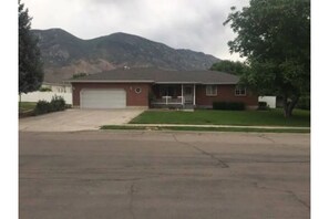 Front of house with white fencing in background that encloses the backyard.