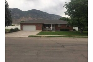 Front of house with white fencing in background that encloses the backyard.