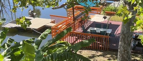 Shaded back yard, outdoor dining, propane grill, tiki hut, gate to floating dock