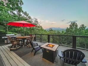 The cabin has a spacious deck with a hot tub, fire pit and outdoor dining area.