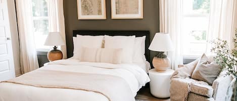 Sleep in luxury: the primary bedroom on the second level boasts an en-suite bathroom and features a queen-sized Purple mattress and Organic Supima Cotton Linens, ensuring a restful and comfortable night's sleep.
