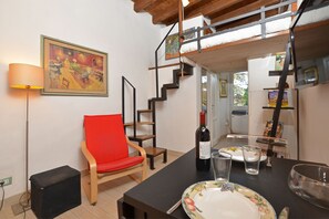 Le salon avec le coin repas et le lit surélevé dans le loft.