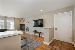 As you enter the home, a spacious living room greets you, complete with an L-shaped sectional, classic coffee table, and plenty of windows that look out into the yard.