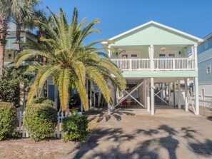 Open underneath and an airy deck with flowing curtains and swinging chair are seen. Even more goodies upstairs!  Just 1 block from the beautiful white-sand beach and the Gulf of Mexico.