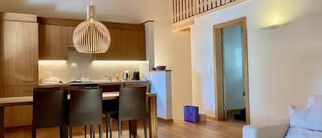 Wohn-, Esszimmer und Küche, die Türe führt in das Schlafzimmer mit dem Etagenbett