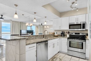 Fully equipped kitchen, featuring modern appliances and ocean view.