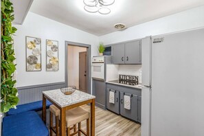Kitchen with oven, refrigerator, storage cabinets, dining table, wall decorations
