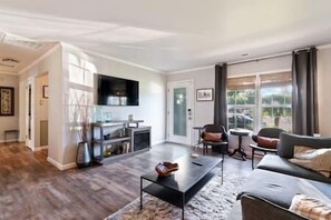 Relax in the spacious living room, featuring cozy seating and a welcoming ambiance—perfect for unwinding after a day out.