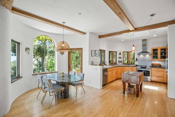 Kitchen and dining area with butcher block and marble table. Miele appliances.