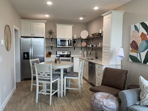 kitchen area, washer/dryer unit through the sliding door to left of fridge