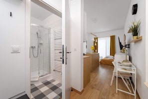 A bathroom with a glass walk-in shower, minimalist design, and plants for decoration.