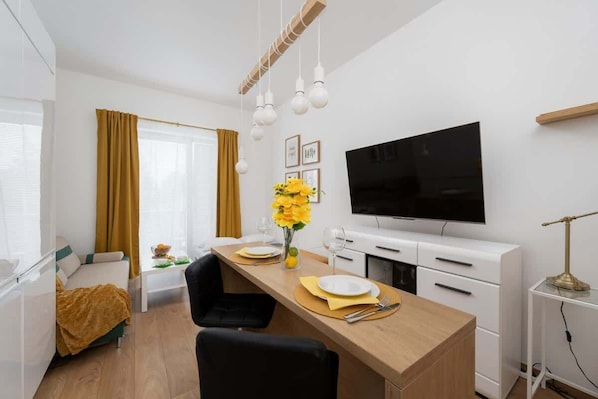 A modern sofa with mustard yellow cushions adds a pop of color to the bright living space.