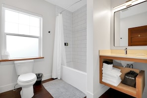 Deep modern bathtub, custom tile & stone countertops.