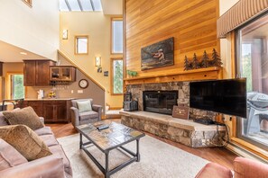 Living area featuring a fireplace, cozy furnishings, and a mounted Smart TV + DVD player.