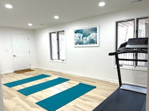 Main House- first floor open gym/ flex space! Please note- there is no longer a treadmill in the room but it does have yoga mats, as well as an 8ft table conveniently located next to a full size fridge.  It can be used for exercise or an additional space for drinking games & enjoying the view!