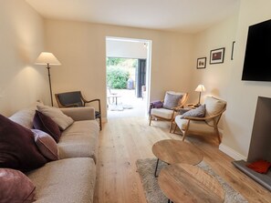 Living room with comfy seating for 8,  Woodburner & wall mounted 55" Smart TV