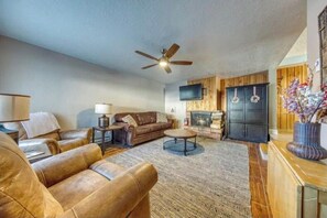 Enjoy quality time in this expansive living room, where you can gather around the coffee table for games or relax in front of the fireplace. The tasteful decor and cozy atmosphere make it the perfect spot for memorable moments. (Living area)